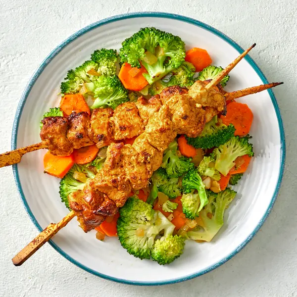 Brochette de poulet au curry et légumes sautés